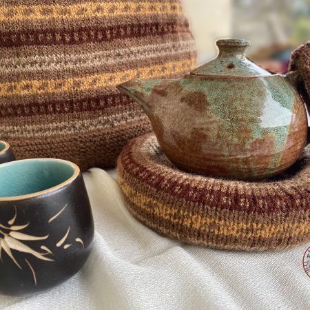 Hand knit woollen tea cosie set with a base, teapot cover and a flap to hold the handle