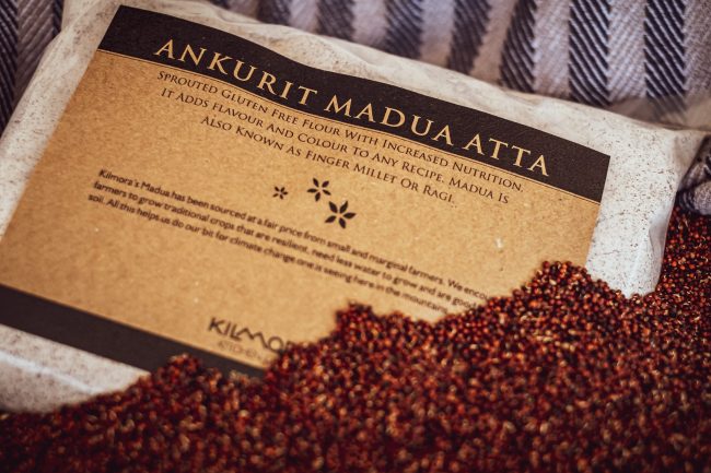 Label saying Ankurit Madua Atta or Sprouted Finger millet Flour with sprouted finger millet strewn across the packet