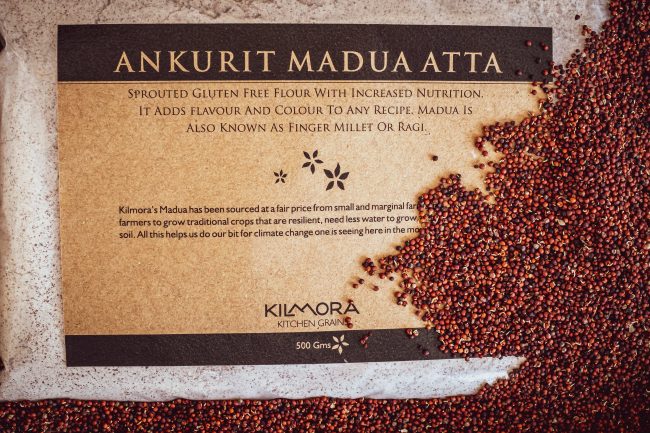 Label saying Ankurit Madua Atta or Sprouted Finger millet Flour with sprouted finger millet strewn across the packet