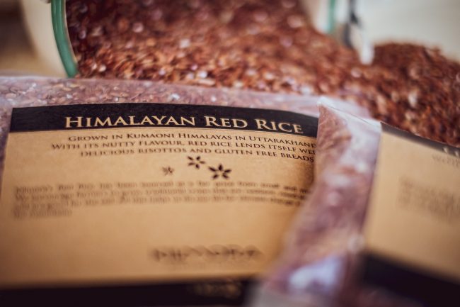 Close up of packet of Himalayan red rice with loose red rice shown in the background