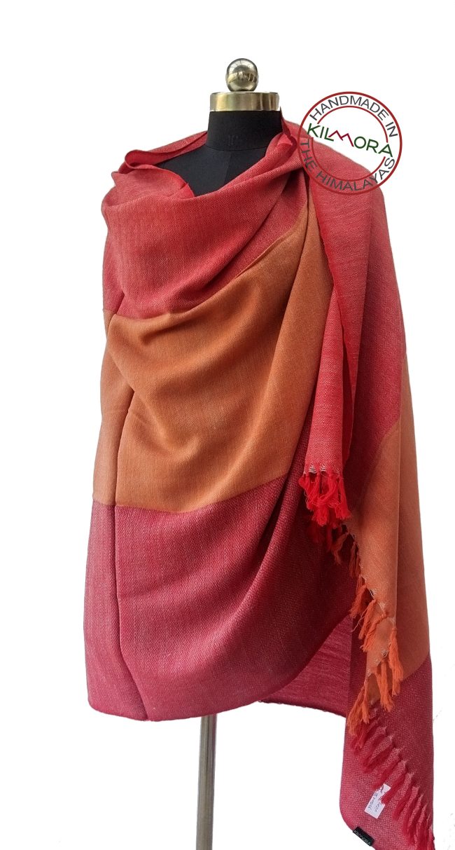 Pure woollen shawl from Kilmora in bold horizontal stripes of shades of raspberry, coral and crimson, underlaid with a weft of white.