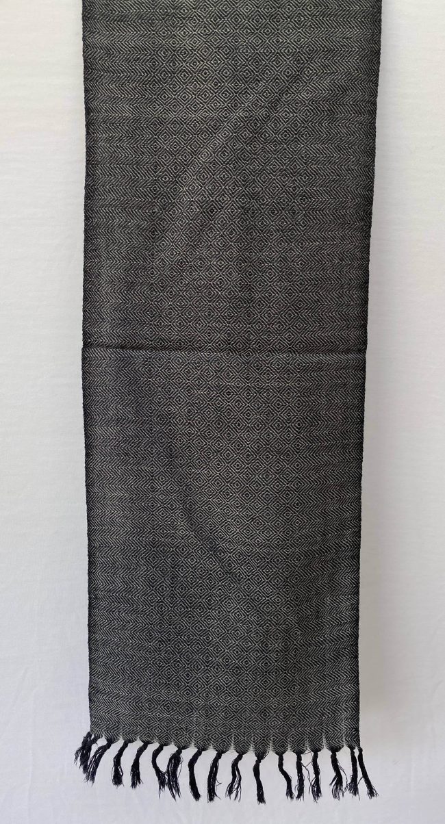 Pure merino wool scarf in black with white undertones. With diamond and herringbone patterns in its weave