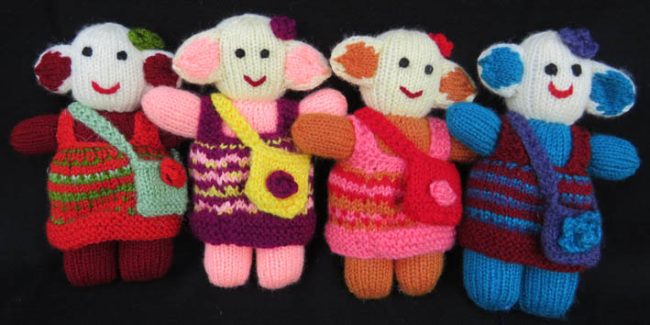 group of 4 knitted soft toys of little girls with small bag slung crossways