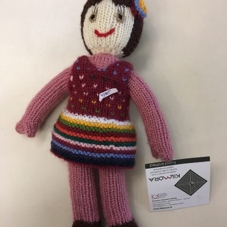 Knitted soft toy of a small girl wearing a polka dotted frock