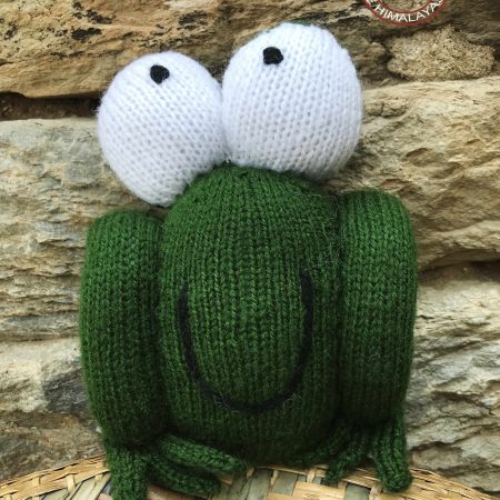 Knitted soft toy in the shape of a frog with bulging eyes and a huge smile