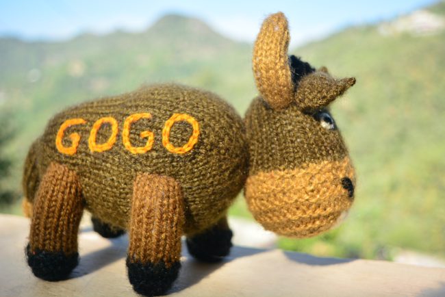 Knitted toy of a bison in brown with name Gogo kntted on the side