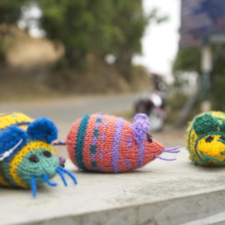 Knitted soft toy in the shape of three multicoloured mouses