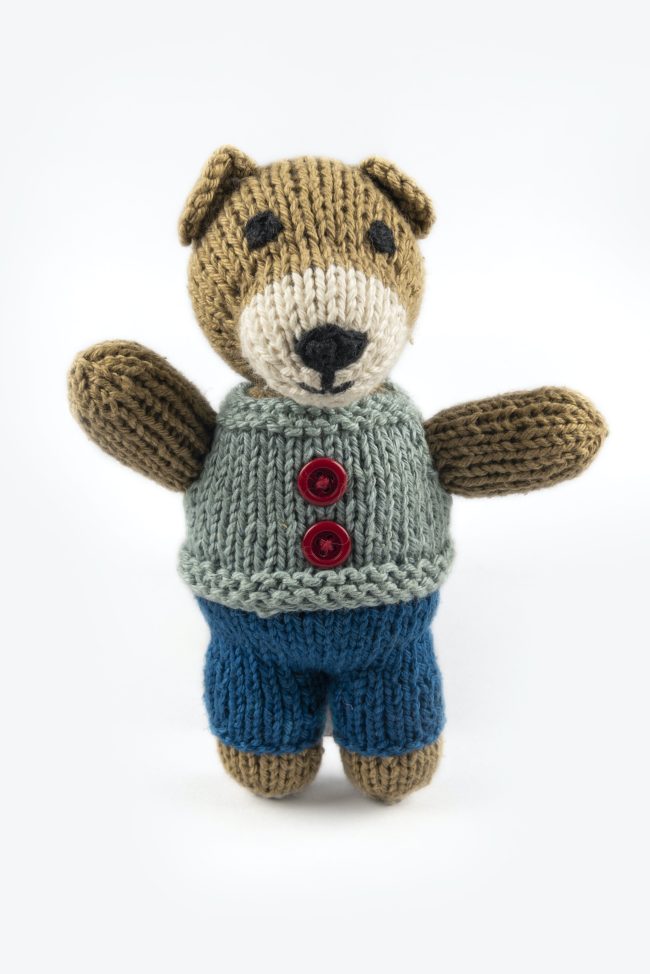 Hand-knit toy bear with dark blue trouser, light blue vest with red buttons