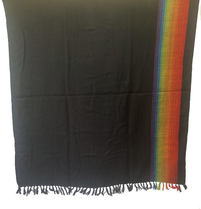 Black merino wool shawl with a border on one side of indigo, blue, yellow, green and red