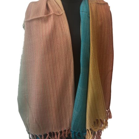 handwoven merino wool shawl in gradation in shades ranging from rust to yellow to peach to pine green