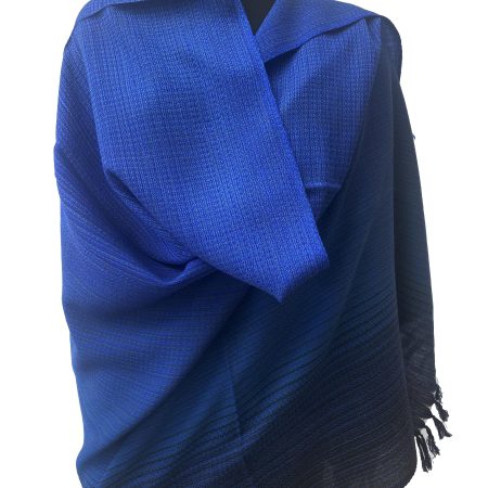 Handwoven merino wool shawl in gradation ranging from azure to sapphireto midnight and royal blue