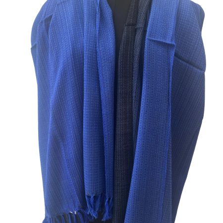 Handwoven merino wool shawl in gradation ranging from azure to sapphireto midnight and royal blue