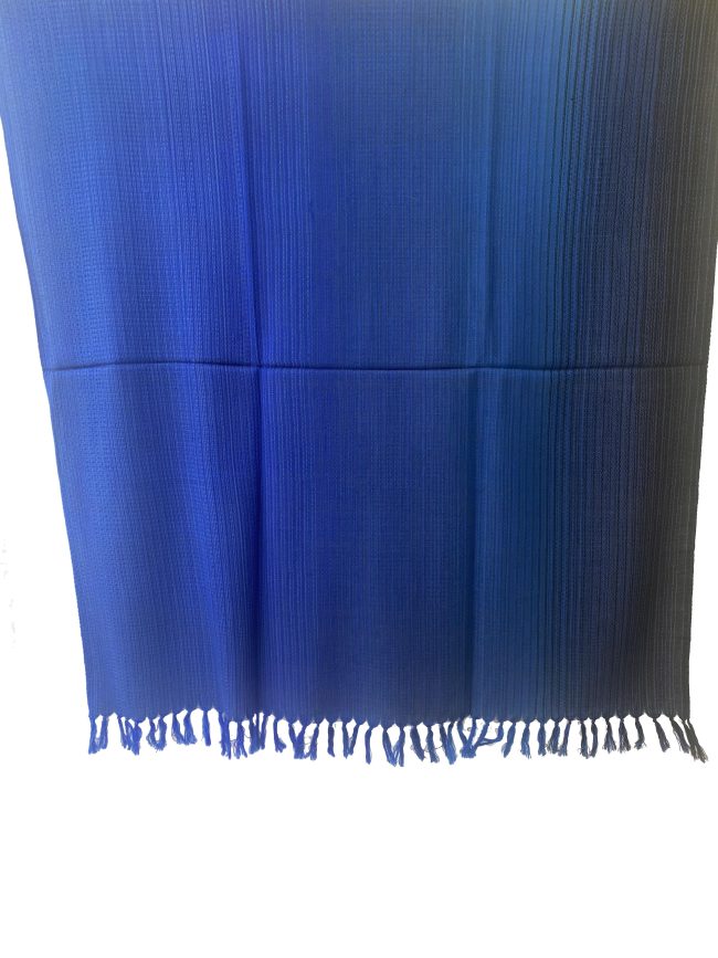 Handwoven merino wool shawl in gradation ranging from azure to sapphireto midnight and royal blue