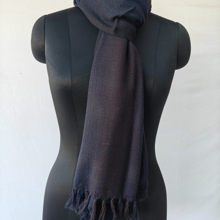 Merino wool stole knotted on a mannequin. In gradation weave - in shades of midnight and royal blue with a hint of orange in the middle