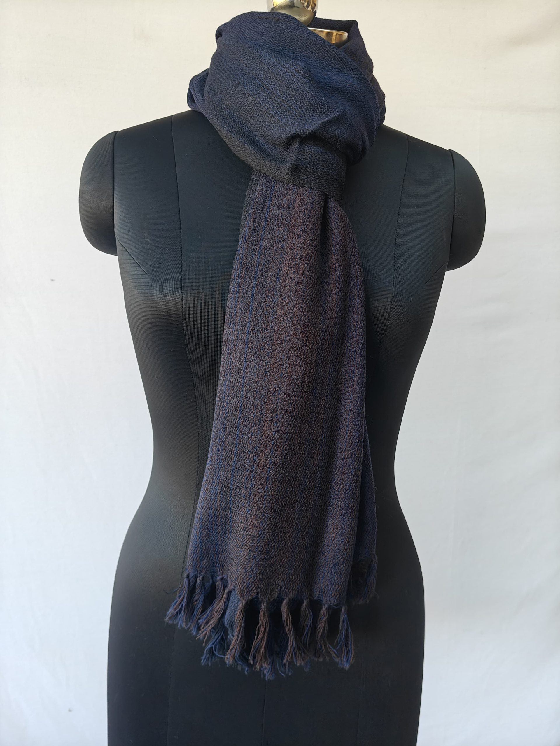 Merino wool stole knotted on a mannequin. In gradation weave - in shades of midnight and royal blue with a hint of orange in the middle