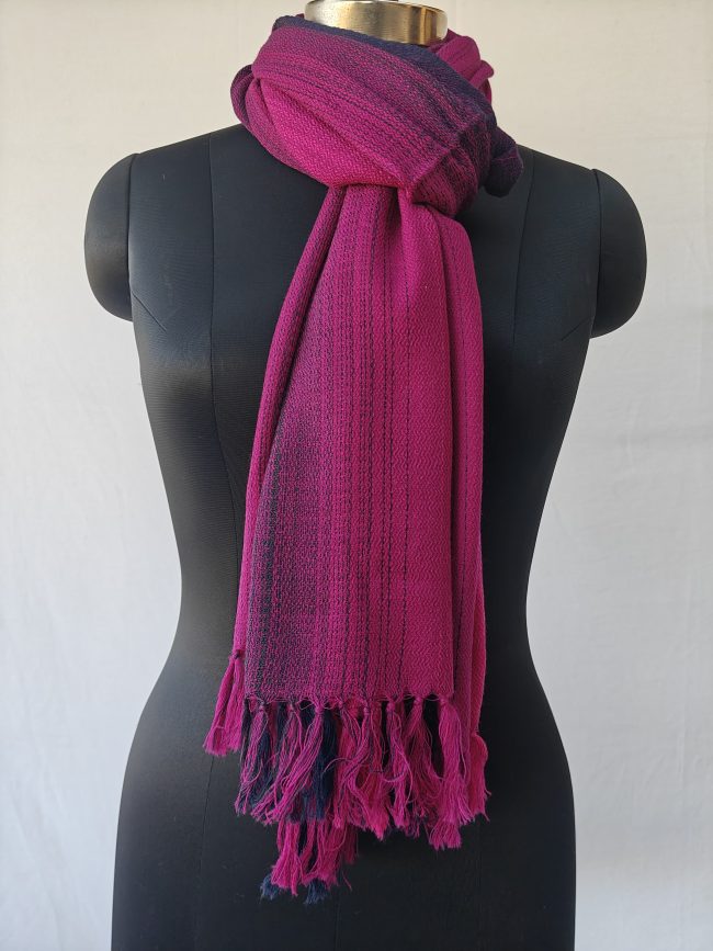 Merino wool stole knotted on a mannequin. In gradation weave - in shades of raspberry pink with amethyst on the sides